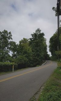 Road amidst trees against sky