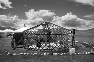 Metal fence on field against sky