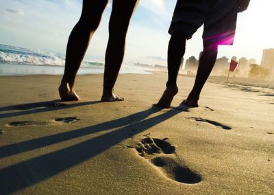 Low section of people standing at beach