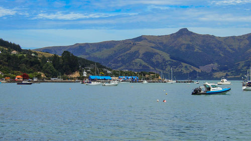 Sailboats in sea against mountains