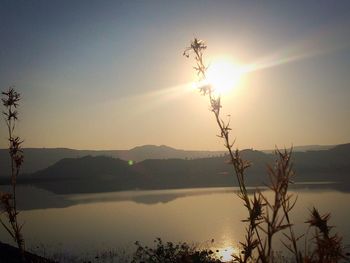 Scenic view of lake against clear sky at sunset