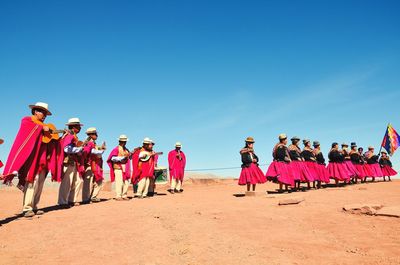 People on beach against clear sky