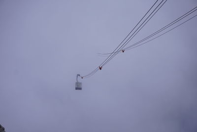 Low angle view of electricity pylon against clear sky