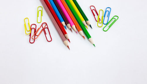 High angle view of colored pencils over white background