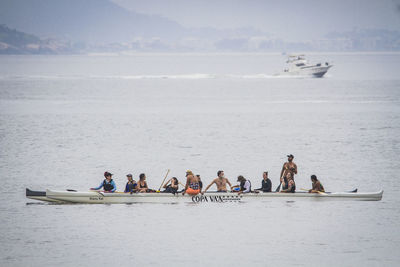 People enjoying in sea against sky