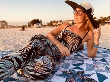 Young woman wearing sunglasses sitting on beach