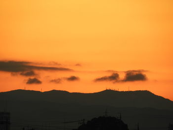 Silhouette mountains against orange sky