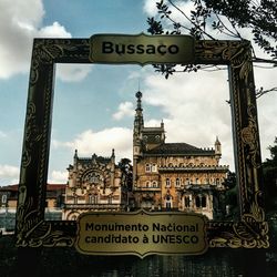 Low angle view of information sign against sky in city