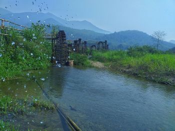 Scenic view of lake by mountain against sky