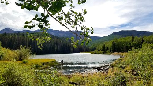 Scenic view of lake by mountains against sky