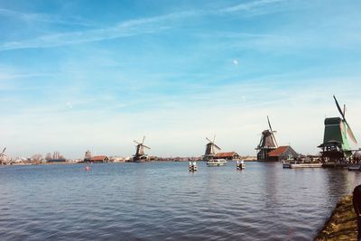 Sailboats in river against sky