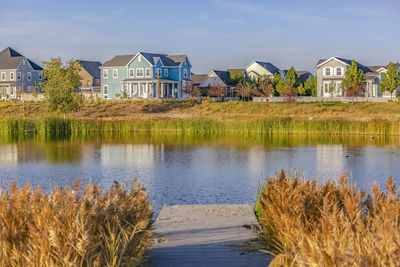 Scenic view of lake by buildings against sky