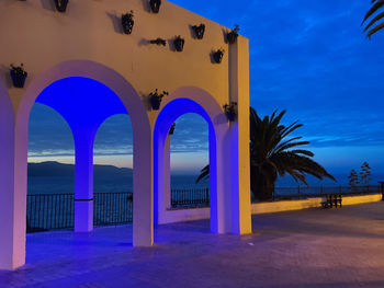 Built structure by sea against blue sky