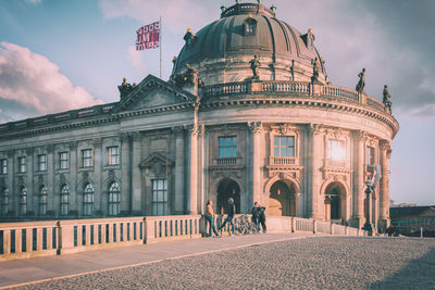 People standing on bridge against bode museum in city