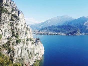 Scenic view of sea and mountains against clear blue sky