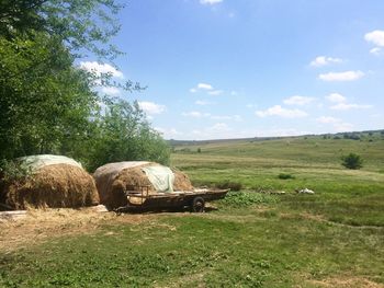 Hay bales on field against sky