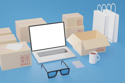 High angle view of laptop on table against blue background