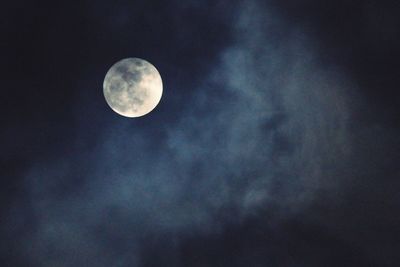 Low angle view of moon in cloudy sky at night