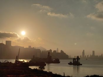 Scenic view of sea and buildings against sky during sunset