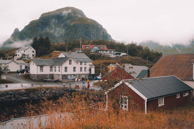 Houses and buildings in town against sky