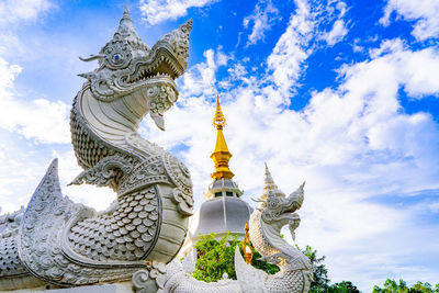 Low angle view of chinese dragon statues at temple against sky