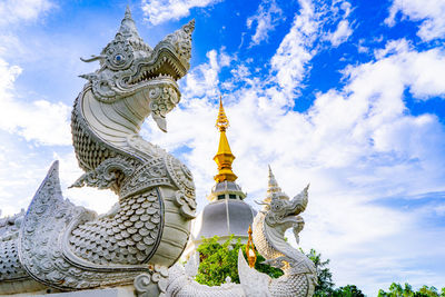Low angle view of statue against temple building against sky