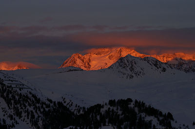 Scenic view of snowcapped mountains against sky during sunset