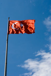 Low angle view of flag against blue sky