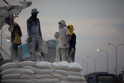 Men unloading cement bags at dockyard