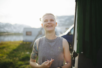 Smiling woman standing at camping site