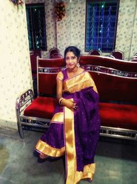 Portrait of smiling young woman sitting on seat