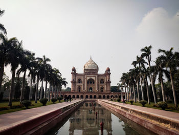 Panoramic shot of mughal era monument with palm trees against sky