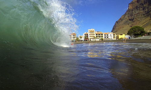 Scenic view of waves against blue sky