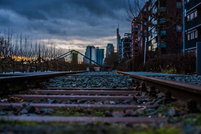 Railroad tracks in city against sky