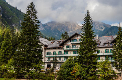 Houses by trees and mountains against sky