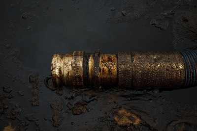 Close-up of rusty pipe on wet shore