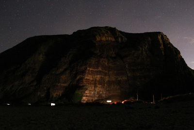 Low angle view of illuminated rock formation against sky at night