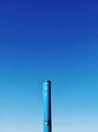 Low angle view of smoke stack against blue sky