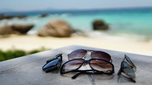 Close-up of sunglasses on beach