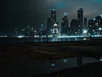 Illuminated buildings against sky at night