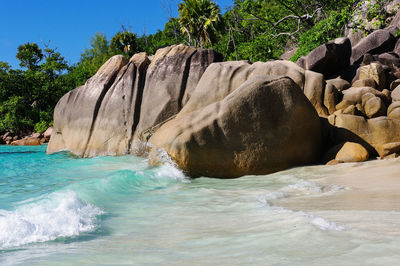 Rock formation on sea shore against sky