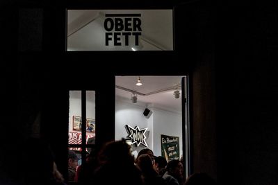 Group of people looking at illuminated sign