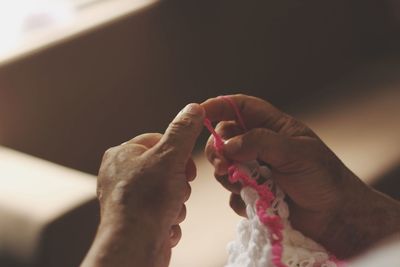 Cropped hands knitting wool at home