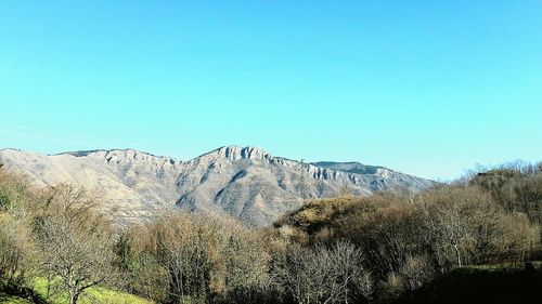 Scenic view of mountains against clear blue sky