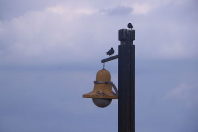 Low angle view of cross against sky