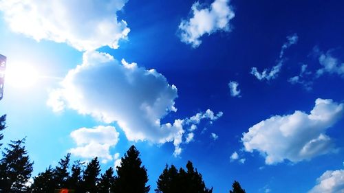 Low angle view of sunlight streaming through clouds