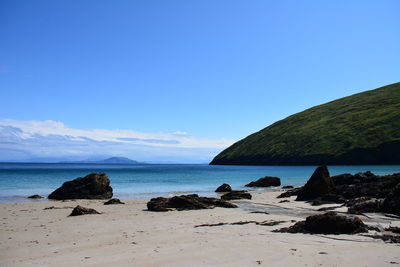 Scenic view of beach against blue sky