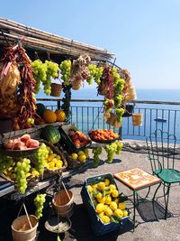 Various fruits for sale against sea at market stall