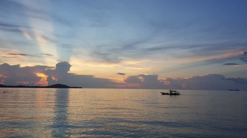 Silhouette boat sailing on sea against sky during sunset