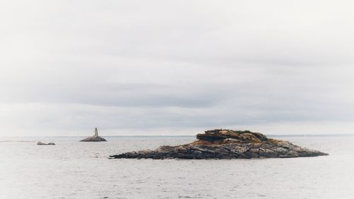 Rocks on sea shore against sky